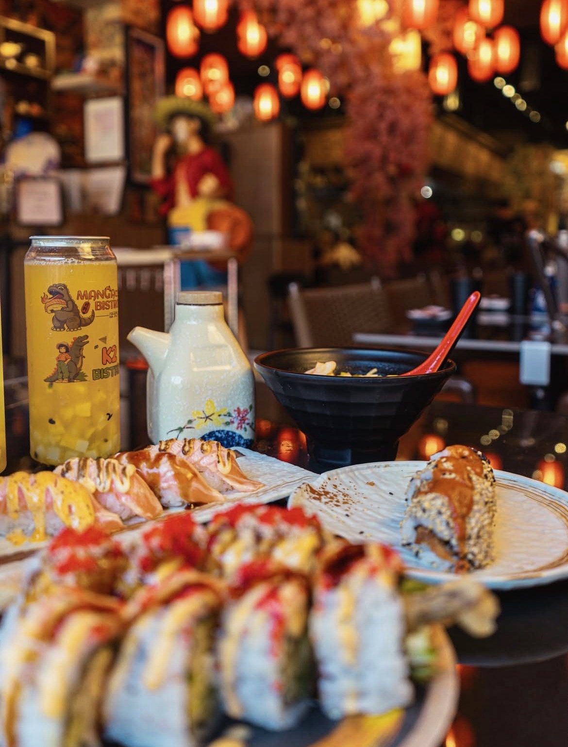 Makis et nigiri brûlés sur une table, sous les lanternes